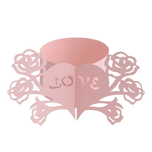 Macro detail of laser-cut pink paper napkin ring with LOVE lettering and rose petals