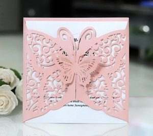 Detail of pink laser-cut butterfly wedding invitation with elegant hollow-out texture