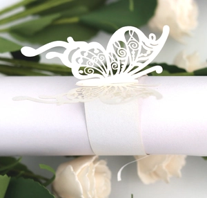 Detail of laser-cut butterfly paper napkin ring in white with intricate hollow pattern