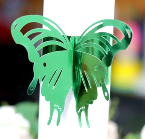 Elegant green laser-cut butterfly napkin ring with metallic finish for wedding decor