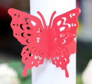 Detail of laser-cut hollow red butterfly napkin ring showing fine symmetrical texture