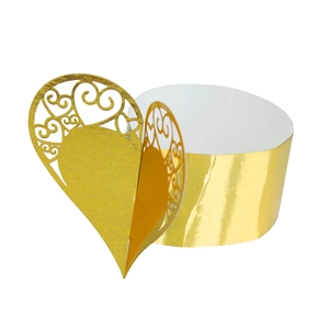 Macro detail of gold laser-cut heart pattern cupcake wrappers for wedding parties