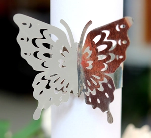 Macro shot of silver hollow butterfly napkin ring with intricate laser-cut metal patterns