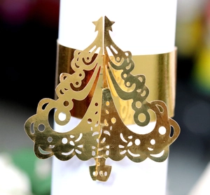 Golden Christmas tree napkin ring with laser-cut hollow patterns for festive table decor