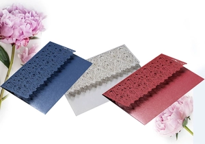 Detailed laser-cut floral edges on elegant blue, white, and red invitation envelopes