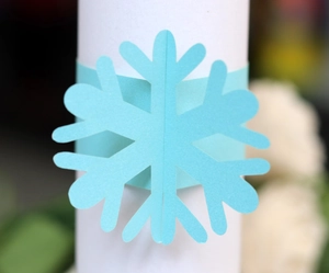 Close-up of light blue laser-cut snowflake paper napkin ring for Christmas decor