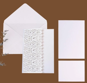 Detail of pink laser-cut wedding invitation card with pearlescent paper and white envelope