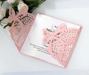 Close-up of pink laser-cut butterfly wedding invitation with pearlescent paper detail