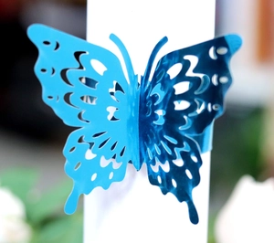 Macro view of bright blue laser-cut 3D butterfly napkin ring with intricate hollow patterns