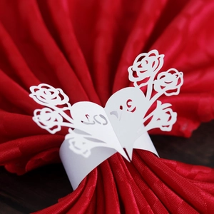 Laser-cut white heart napkin rings with LOVE lettering on red fabric napkin