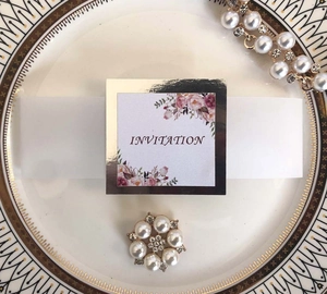 Détail de la carte d'invitation avec support doré et accessoire en perle et strass