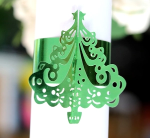 Glossy green Christmas tree napkin ring with hollowed scroll pattern for holiday tables