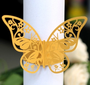 Macro shot of gold butterfly napkin ring featuring intricate laser-cut hollow patterns
