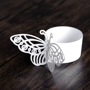 Close-up of white laser-cut butterfly napkin ring with intricate hollow patterns