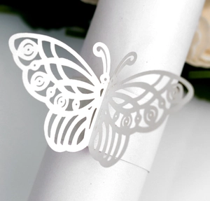 Macro detail of laser-cut white butterfly napkin ring for elegant wedding table decor