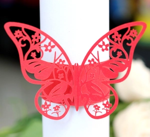 Macro shot of laser-cut red butterfly napkin ring with intricate hollow floral patterns