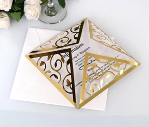 Elegant laser-cut hollow gold wedding invitation set with floral patterns and white envelope