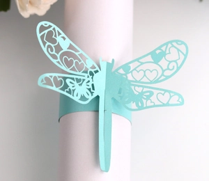 Detail of laser-cut dragonfly napkin ring in mint blue with intricate hollow patterns