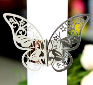 Macro shot of silver butterfly napkin ring with laser-cut hollow floral pattern