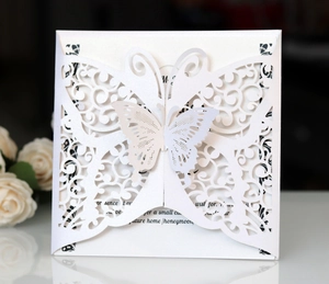 Detail of laser-cut butterfly wedding invitation with white pearlescent paper finish