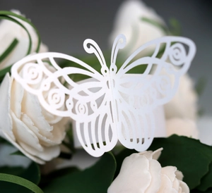 Macro detail of laser-cut white paper butterfly napkin ring with delicate hollow texture