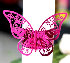 Macro shot of laser-cut magenta butterfly napkin ring with reflective mirror finish