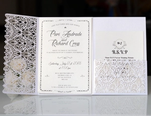 Close-up of laser-cut lace wedding invitation with tri-fold detail and RSVP card set