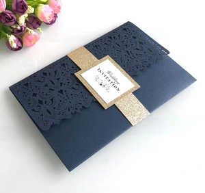 Detail of dark blue laser-cut wedding invitation with gold glitter band and floral patterns