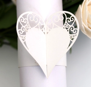 Close-up of white laser-cut heart napkin ring with elegant floral scroll design
