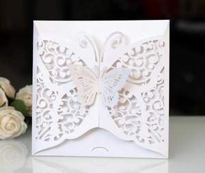 Macro shot of laser-cut butterfly invitation cover with elegant pearlescent glitter texture
