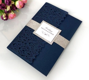 Laser cut navy blue wedding invitation with silver glitter band and floral cutout patterns