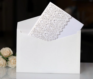 Detail of white laser cut invitation card with floral pattern and premium envelope