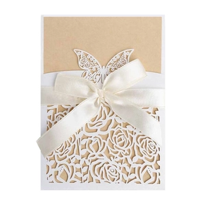 Detailed laser-cut white rose and butterfly wedding invitation with cream satin bow