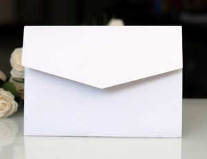 Detail of white pearlescent paper envelope with V-flap and elegant floral decor