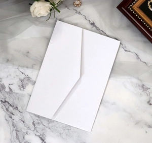 Elegant white V-flap envelope placed on marble with lace and roses for wedding stationery