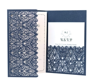 Detail of laser-cut navy blue wedding invitation with intricate vine lace patterns