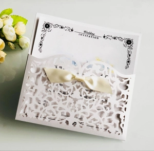Détail d'une invitation de mariage découpée au laser avec un élégant nœud en satin crème