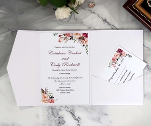 Detail of floral kraft wedding invitation set with RSVP card on marble background