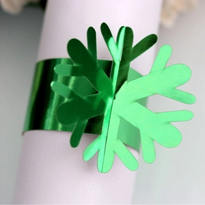 Deep green snowflake napkin ring with metallic gold accent for festive table decor
