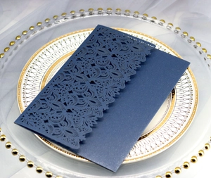 Detail of laser-cut navy blue wedding invitation with intricate floral lace pattern