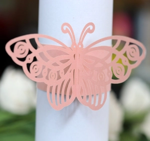 Macro view of laser-cut pink butterfly napkin ring with detailed hollow-out patterns