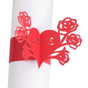 Detail view of red laser-cut paper napkin ring with LOVE lettering and roses
