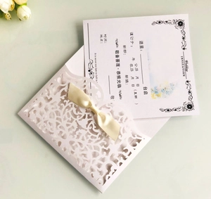 Détail du faire-part de mariage découpé au laser avec nœud en soie et fleurs