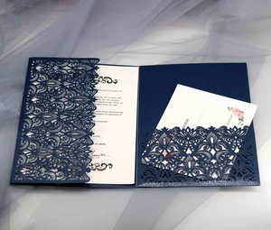 Macro detail of laser-cut navy blue lace wedding invitation with intricate hollow floral patterns