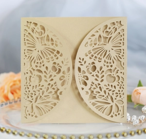 Detail showing elegant champagne gold laser-cut butterfly invitation on a pearl plate