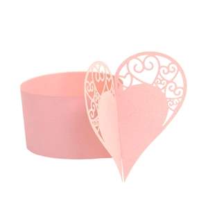 Detail of pink laser-cut paper napkin ring featuring a delicate hollow heart design