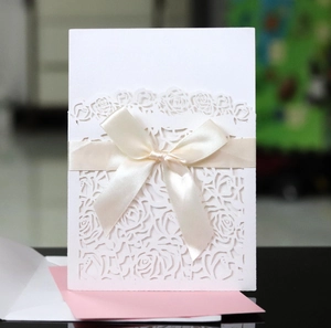 Détail de motifs de roses découpés au laser sur une invitation de mariage blanche élégante