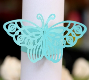Detail of laser-cut butterfly napkin ring in mint green with elegant hollow patterns
