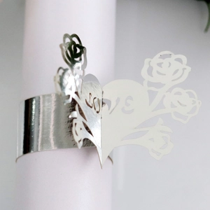 Macro detail of silver laser-cut LOVE napkin ring with rose and heart patterns