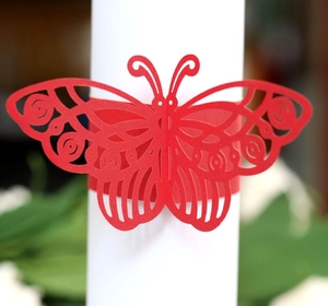 Close-up of red laser-cut paper butterfly napkin ring with intricate hollow detail